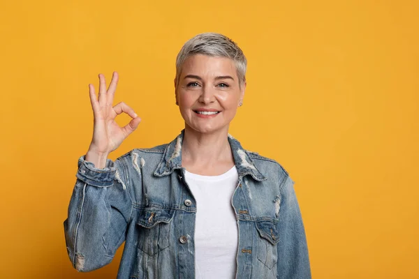 Está tudo bem. Feliz mulher de meia-idade gestos ok sinal e sorrindo — Fotografia de Stock