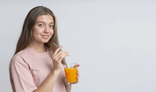 若いです陽気な女の子飲むオレンジジュースとともにわら — ストック写真