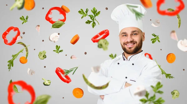 Zdravá výživa. Profesionální šéfkuchař a létající zelenina na šedém pozadí, koláž. Prázdné místo — Stock fotografie