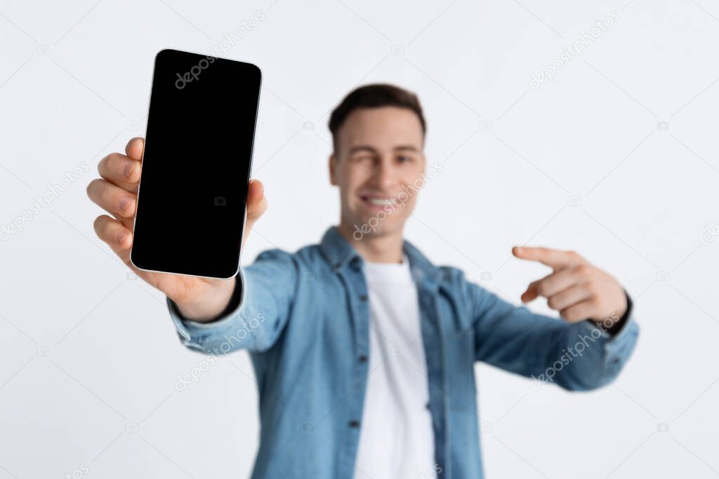 Guy points finger at empty screen of smartphone