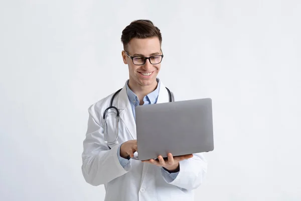 Smiling doctor in glasses and laptops in hands — Stock Photo, Image