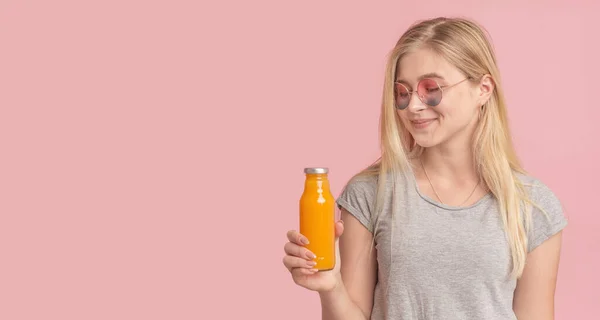 スタイリッシュな女の子飲むデトックスジュースからガラス瓶オンピンク — ストック写真