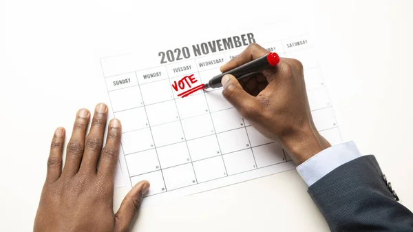 Afrikai férfi írásban szavazat szöveget naptár, amerikai általános választás — Stock Fotó