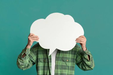 Milenyum adamı, turkuaz arka planda konuşma balonuyla yüzünü kapatıyor. Tasarım için yer var.