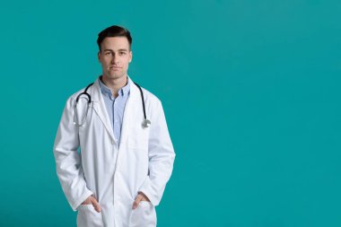 Steteskopu olan yakışıklı bir doktor, elleri cebinde.