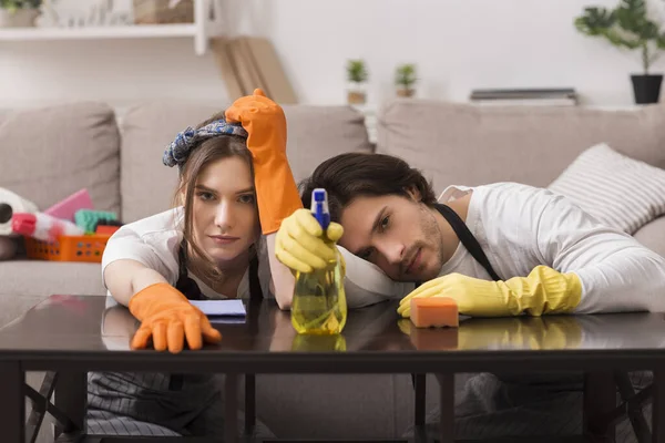 Limpeza de rotina. Cansado casal inclinado na mesa, exausto depois de arrumar apartamento — Fotografia de Stock