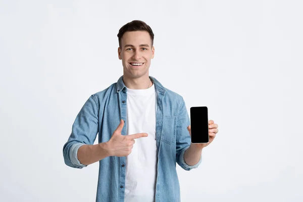 Kerl zeigt mit dem Finger auf leeres Bildschirm-Telefon — Stockfoto