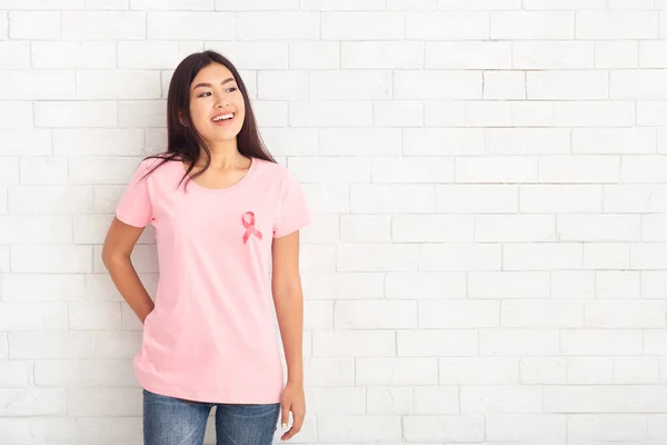 Asiática chica con conciencia cáncer cinta posando sobre blanco pared —  Fotos de Stock