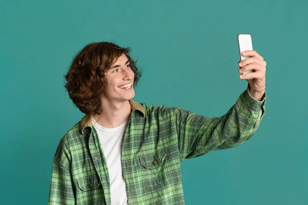 Akıllı telefonlu kıvırcık çocuk renk geçmişinde selfie çekiyor. — Stok fotoğraf