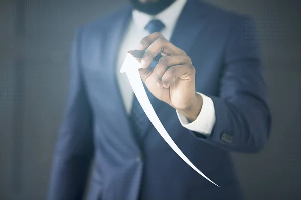 Бизнесмен держит Stylus Drawing Arrow Going Up на виртуальной панели — стоковое фото