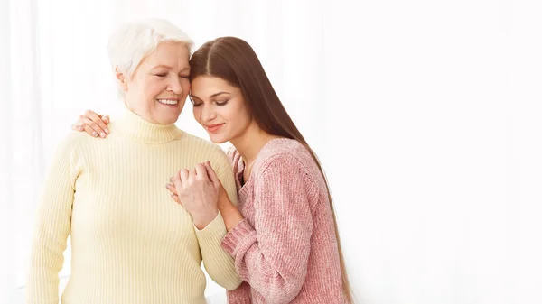 Mulher amorosa abraçando a mãe, posando para foto de família — Fotografia de Stock