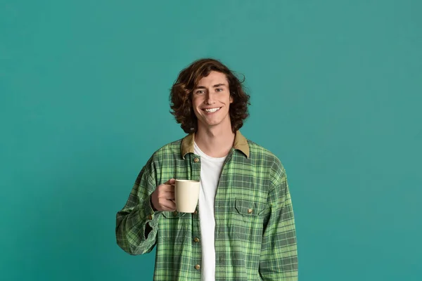 Arka planda bir fincan kahve tutan havalı genç adam. — Stok fotoğraf