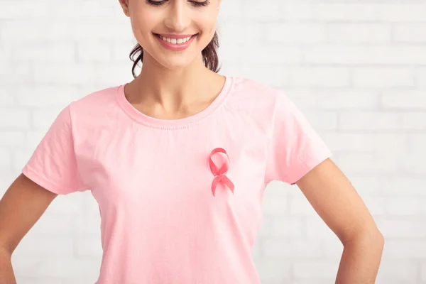 Неузнаваемая девушка с розовой лентой на футболке Поза, белый фон — стоковое фото