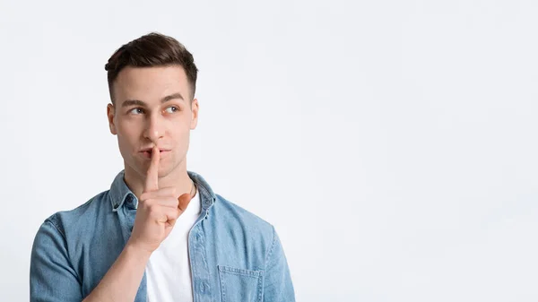 El hombre presiona el dedo a los labios hace señal de silencio —  Fotos de Stock