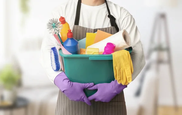 Uomo in uniforme ciotola con vari strumenti di pulizia — Foto Stock