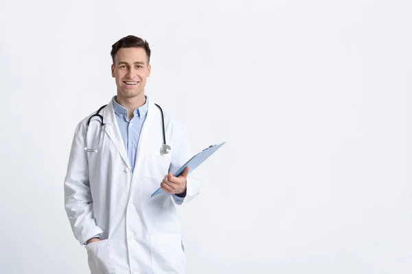 Médecin souriant en manteau blanc avec comprimé — Photo