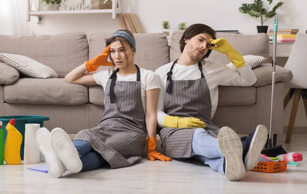 Portrait de couple épuisé assis sur le sol après avoir nettoyé l'appartement — Photo