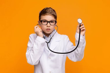 Stetoskop tutan doktor üniformalı ciddi bir genç.