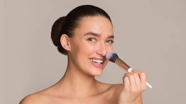 Güzel beyaz kadın fırçasını kullanıyor.