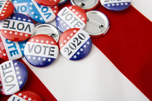 American vote badges on national USA flag background — Stock fotografie
