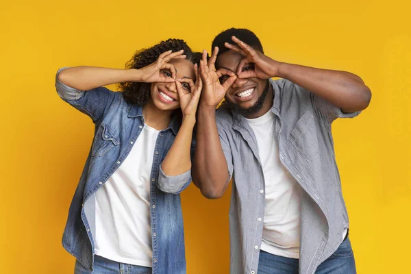 Vrolijk Afrikaans Amerikaans paar het maken van grappige bril met vingers, gek samen — Stockfoto