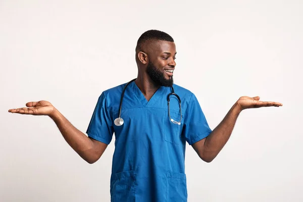 Heyecanlı Afrikalı doktor ellerinde görünmez bir şey tutuyor. — Stok fotoğraf
