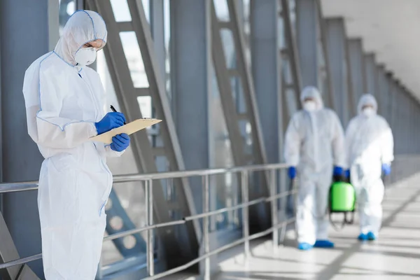 Virologists in protective hazmat suits controlling epidemic — Stock Photo, Image