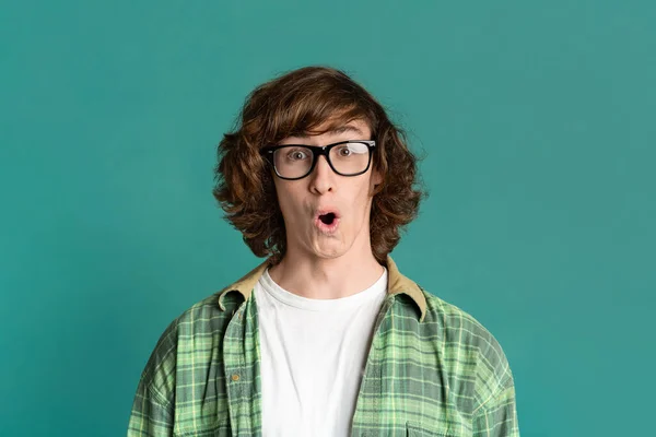 Shocked millennial guy with glasses on color background — Stock Photo, Image