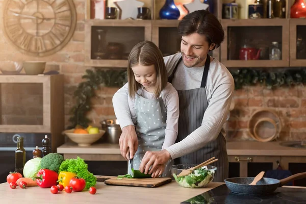 Gondoskodó apa megtanítja imádnivaló lányát egészséges ételeket főzni. — Stock Fotó