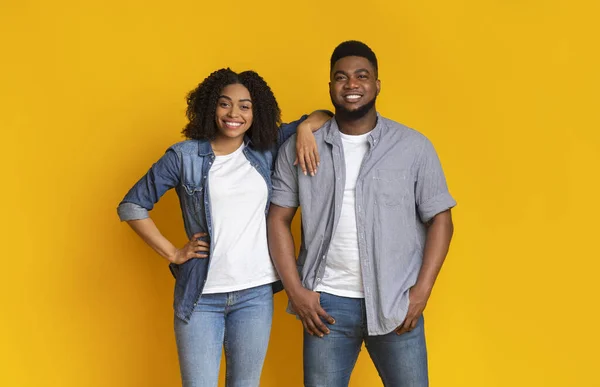 Cool Millennials. Attractive young black couple posing together over yellow background — Stock Photo, Image