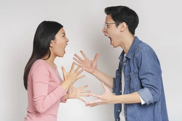 Asiático hombre y mujer luchando sobre gris fondo — Foto de Stock