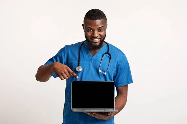 非裔美国医生指着空白的笔记本电脑屏幕 — 图库照片