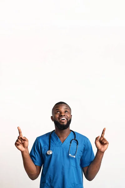 Şaşırmış Afrikalı Amerikalı doktor boş alanı işaret ediyor. — Stok fotoğraf