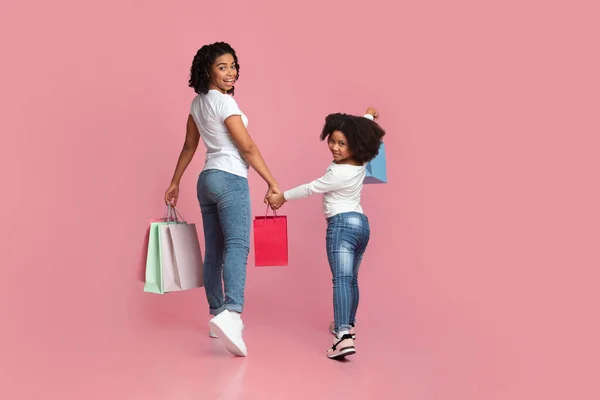 Joven madre africana e hija pequeña caminando con bolsas de compras —  Fotos de Stock