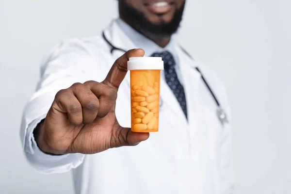 Médico masculino afroamericano recomendando pastillas, recortadas — Foto de Stock