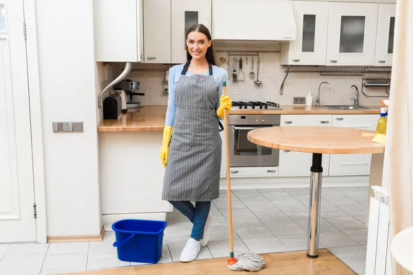 Mladá žena drží mop na čisté podlaze — Stock fotografie