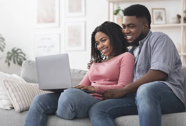 Fröhliches schwarzes Paar mit Laptop zu Hause, Bestellung von Essenslieferung — Stockfoto