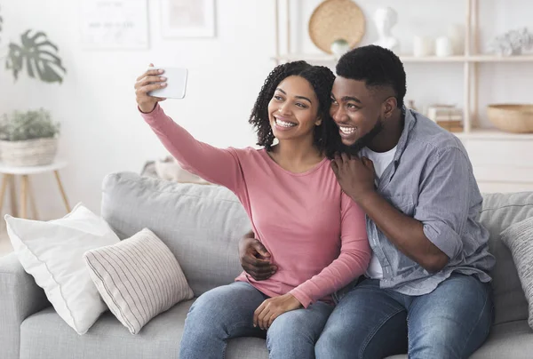 隔離セルフィー。自宅でスマホで写真を撮る黒人夫婦の笑顔 — ストック写真