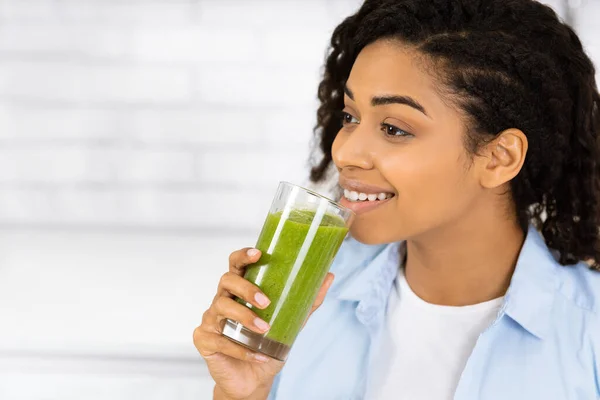 Afro menina bebendo smoothie e olhando para fora — Fotografia de Stock