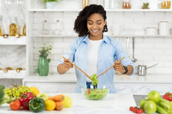 Красивая молодая черная девушка готовит овощной салат — стоковое фото