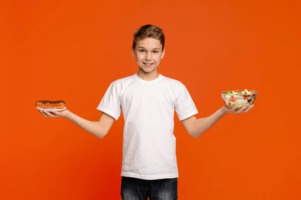 Tiener jongen met verse salade en chocolade donut — Stockfoto