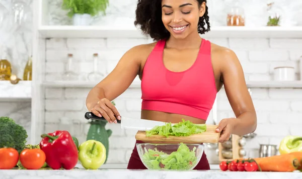 Vacker ung svart flicka förbereder grönsakssallad hemma — Stockfoto