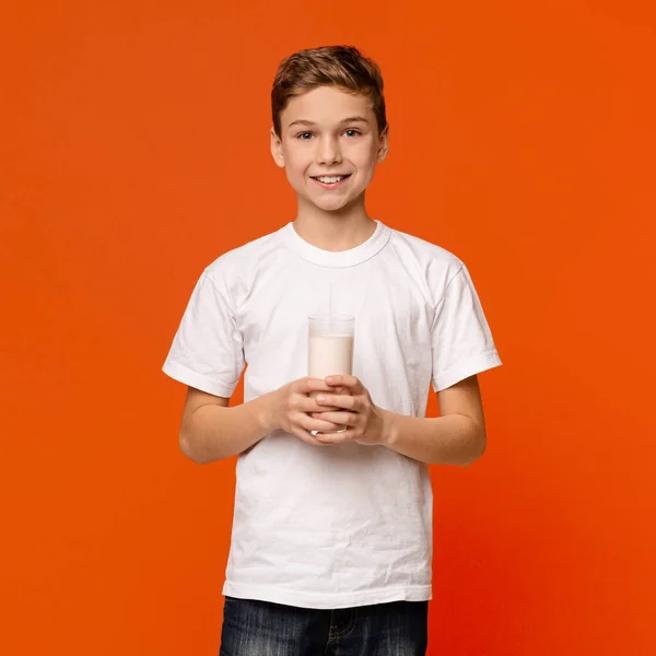 Vrolijke tienerjongen glimlachend met een glas verse melk — Stockfoto