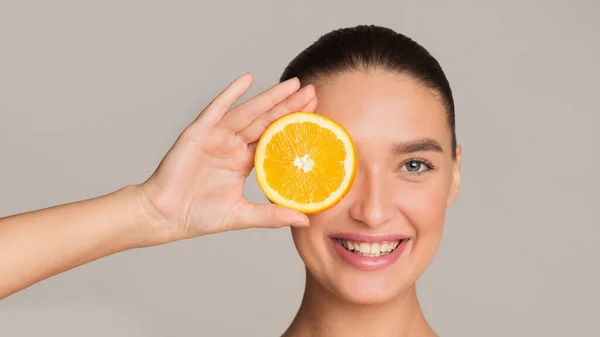 Concepto desintoxicación. Mujer sosteniendo pedazo de naranja — Foto de Stock