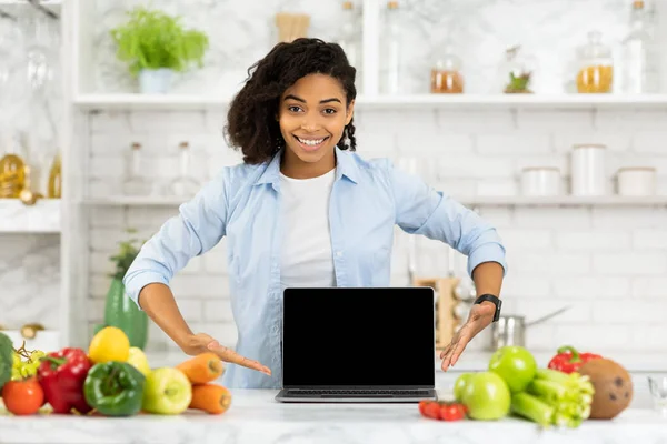 Africano ragazza che punta al computer portatile in cucina — Foto Stock