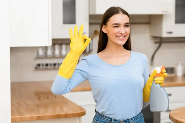 Mujer joven con guantes de goma amarillos mostrando signo de ok — Foto de Stock