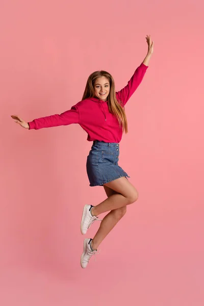 आनंदी किशोरवयीन मुलगी गुलाबी पार्श्वभूमी वर उडी — स्टॉक फोटो, इमेज