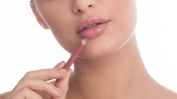 Femme méconnaissable appliquant une couche de lèvre nue en studio — Photo