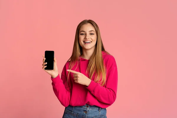Meisje wijst naar smartphone met leeg scherm — Stockfoto