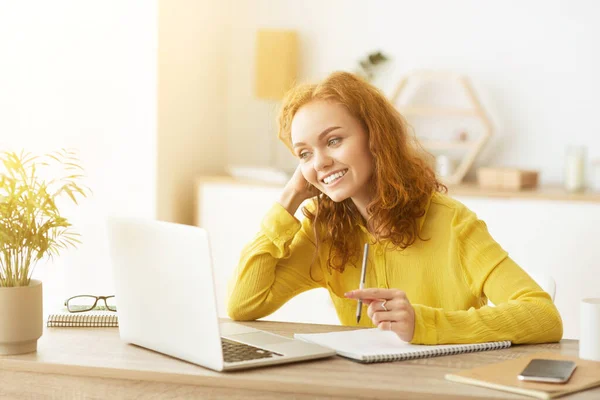 Young student working on laptop and writing notes — Stock Photo, Image